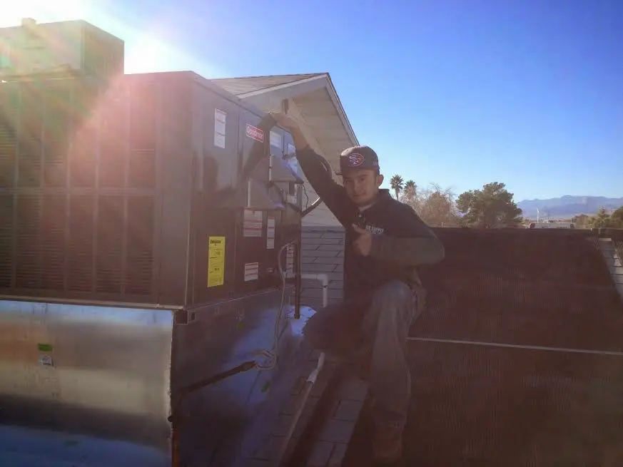 HVAC technician performing Heat Pump Repair on a rooftop unit in Huntington Woods
